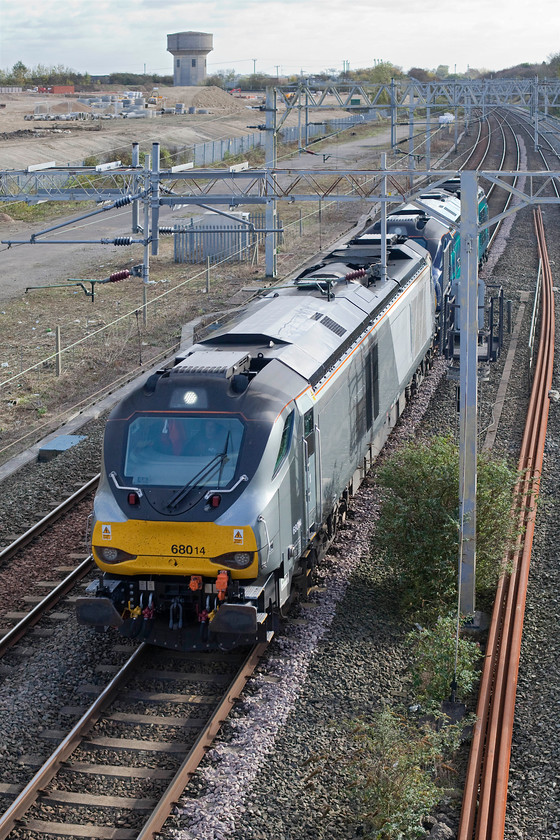 68014 & 68009, 09.35 Wembley-Crewe Gresty Bridge (0K69), site of Roade station 
 68014 and 68009 'Titan' form the 09.35 Wembley to Crewe Gresty Bridge light engine movement. This 0K69 working was running about three hours late by this stage as it passes the site of the closed Roade station. In the background, the clearance is now virtually complete of the old Pianofort factory site with the infrastructure being installed for the new houses that are to be built. 
 Keywords: 68014 68009 09.35 Wembley-Crewe Gresty Bridge 0K69 site of Roade station