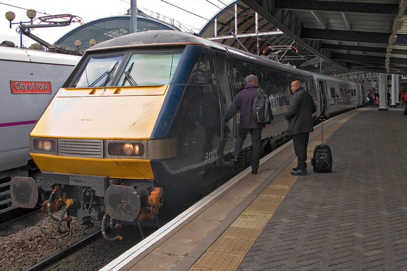 91121, GR 09.00 London King's Cross-Edinburgh Waverley (1S09) & 91102, Newcastle station 
 I have popped out of our train at Newcastle station as a crew change takes place. 91121 is working the 09.00 King's Cross to Edinburgh service whilst 91102 'City of York' is seen at the rear of an unidentified southbound service. The contrast between the two liveries is plain to see with 91121 still wearing its GNER paint but rebranded with East Coast vinyls. 
 Keywords: 91121 09.00 London King's Cross-Edinburgh Waverley 1S09 91102 Newcastle station City of York