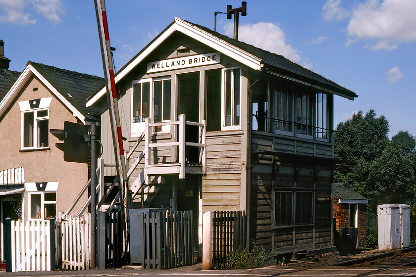 Welland Bridge signal box (GE, 1882) 
 Welland Bridge signal box was a Great Eastern 1882 structure that was the first box from the north after the former GN & GE Joint line left the Peterborough line in Spalding. It was at the point where the line crossed the River Welland with a level crossing on either bank on London and Cowbit Roads. The box closed when the line was shut in November 1982 but fortunately, it lives on in a new form named Woodstone Wharf located at the Peterborough NV station on the Nene Valley Railway. Unfortunately, the same cannot be said of the houses to the left in this photograph both of which have been demolished to make way for the inevitable housing estate. 
 Keywords: Welland Bridge signal box GE Great Eastern