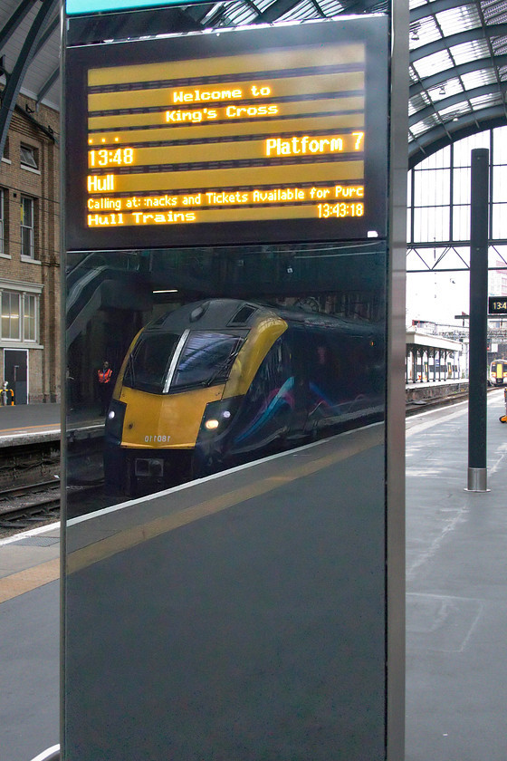 180110, HT 13.48 London King`s Cross-Hull (1H04, 8L), London King`s Cross station 
 180180 is seen reflected in an electronic display stand on platform seven of King's Cross. The 180 will work the Hull Trains 13.48 to Hull. Walking the length of the train, it was heavily loaded indicating that this relatively small operator (part of First Group) is getting things right. The introduction into service of the class 802 bi-mode trains, that are on order, later this year should alleviate the overcrowding issues as well as meaning these unreliable class 180s can be withdrawn for a second time! 
 Keywords: 180110 13.48 London King`s Cross-Hull 1H04 London King`s Cross station