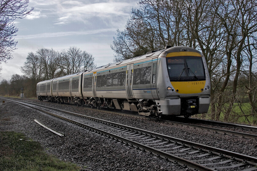 168110, CH 08.07 London Marylebone-Birmingham Moor Street (1R14 RT), Claydon crossing SP451498 
 With the sun just putting in an appearance, but in this instance causing the 08.07 Marylebone to Birmingham Moor Street to be rather backlit, it is captured passing near Claydon worked by 168110. These units remain the mainstay of Chiltern's operations throughout their network with the TOC still persevering with locomotive-hauled trains for some services. 
 Keywords: 168110 08.07 London Marylebone-Birmingham Moor Street 1R14 Claydon crossing SP451498 Chiltern Turbo