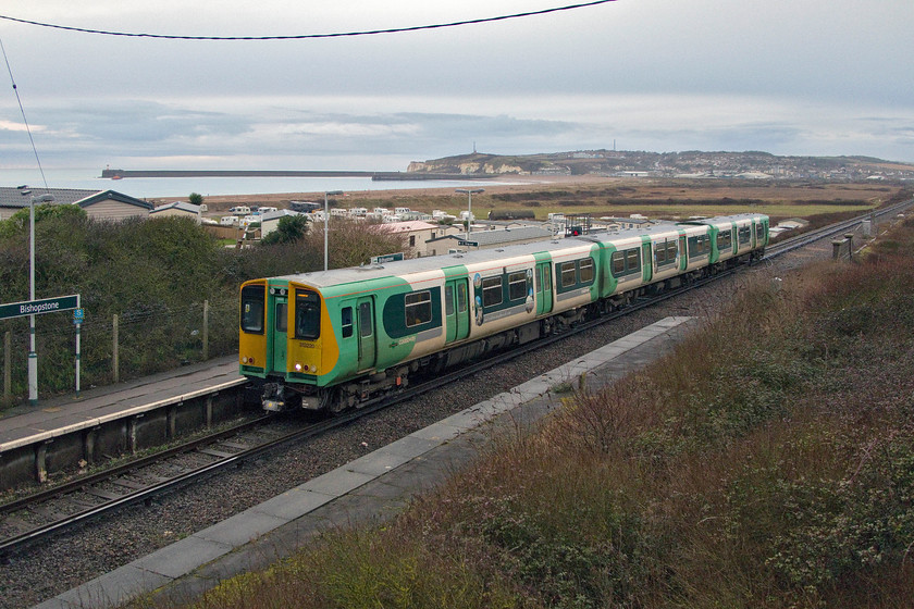 313220, SO 16.11 Brighton-Seaford (2C44, RT), Bishopstone station 
 In the dying early evening light, 313220 arrives at Bishopstone station with the 16.11 Brighton to Seaford service. In the background, the breakwaters of Newhaven Harbour can seen and a calm English Channel. Bishopstone station enjoys a regular service operated by Southern but only has one of its former two platforms in use. It saw a significant increase in traffic between 1939 and 1945 with the addition of a bay platform. 
 Keywords: 313220 16.11 Brighton-Seaford 2C44 Bishopstone station