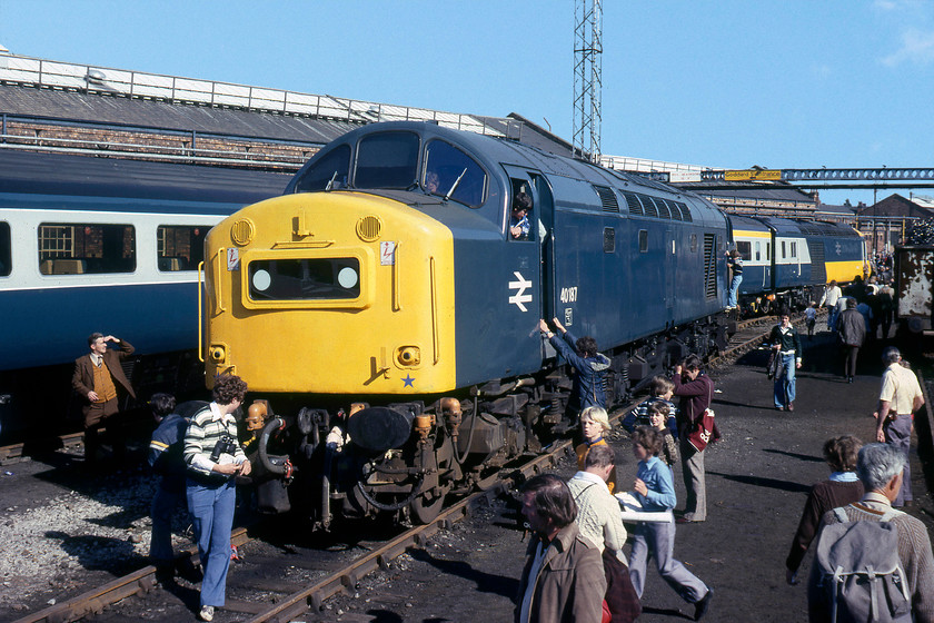 40187, awaiting attention & 253031, awaiting delivery, Crewe Works 
 The old and new order stand side-by-side at Crewe Works. In the background, HST set 253031 looks complete and ready to be released into traffic. Indeed, this happened a week after this picture was taken with it moving to the Western Region for use on the west of England services. This HST set had power cars 43131 and 43132 at either end, my records do not show which one is seen in this image. In the foreground, 40187 is being heavily 'cabbed', I am unsure if this was official or just that the doors had been left unlocked and a bit of opportunism ensued? The 40 had completed a spell at Crewe during the spring, receiving classified repairs. Unfortunately, some four months later, it is seen back again for 'rectification repairs'. These repairs took some time, being not completed until February 1980. 40187 survived in traffic for another two years until August 1981, withdrawn at Stratford, succumbing to bogie fractures, a problem that plagued so many of the class. 
 Keywords: 40187 253031 Crewe Works