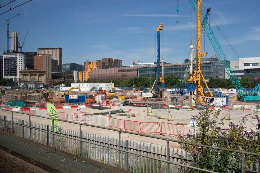 HS2 site, Birmingham Curzon Street 
 The development and construction of the HS2 Birmingham terminal continues close to the city centre. Notice the tiny 1883 Curzon Street building completely dwarfed by the surrounding buildings and the development itself. The historic building is to be retained and become part of the huge HS2 terminus. I took another image from a train window back in 2017 before any developments had begun, see .... https://www.ontheupfast.com/p/21936chg/25077288404/former-curzon-street-station 
 Keywords: HS2 site Birmingham Curzon Street