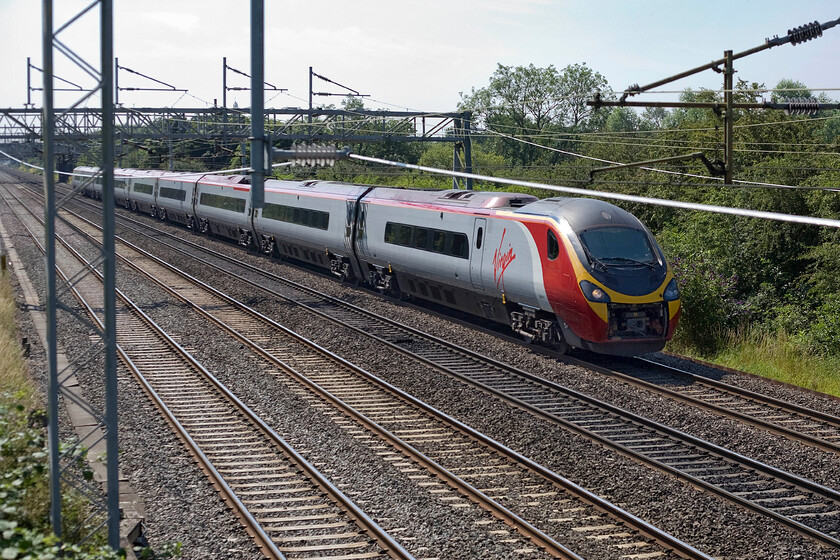 Class 390, VT 10.00 London Euston-Manchester Piccadilly (1H64), Bradwell SP831391 
 With the return wire almost spoiling the party an unidentified Class 390 Pendolino passes Bradwell in Milton Keynes working the 1H64 10.00 Euston to Manchester service. Getting a photograph at this location is extremely tricky hence the inclusion of the said return wire due to the extra security measures attached to the bridge. 
 Keywords: Class 390 10.00 London Euston-Manchester Piccadilly (1H64), Bradwell SP831391 Virgin Pendolino