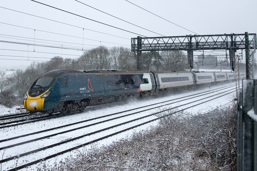 390112, VT 09.38 Liverpool Lime Street-London Euston (1A09, 7L), Roade Hill 
 The snow has started again after a couple of hours of steady precipitation as 390112 passes between Roade and Ashton on the southern WCML. The Avanti West Coast Pendolino is working the 1A09 09.38 Liverpool to Euston, a journey of just under two hundred miles. This service is one of those remaining after Network Rail, Avanti and the Government have recently culled the timetable in the wake of the latest COVID-19 lockdown that has witnessed passenger numbers haemorrhage once again with a very uncertain future ahead for the railways. 
 Keywords: 390112 09.38 Liverpool Lime Street-London Euston 1A09 Roade Hill Avanti West Coast Pendolino