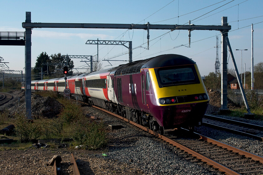 43274, EM 05.19 Leeds-London St. Pancras (1C15, 4E), Wellingbrough station 
 I am not at all sure if EMR 'purple nasty' livery suits the HST power cars? Either way, this one-off variant will not be in operation for very much longer with them being withdrawn from service in just over two weeks' time. 43274 brings up the rear of the 05.19 Leeds to St. Pancras train as it leaves Wellingborough. InterCity Swallow liveried 43102 'The Journey Shrinker' leads the train partially obscured by an electrification mast. 
 Keywords: 43274 43102 43302 05.19 Leeds-London St. Pancras 1C15 Wellingborough station East Midland Railway HST The Journey Shrinker