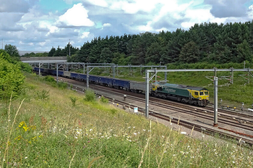 66504, 10.59 New Bilton-Willesden Eurotunnel (4R98, 12E), Loughton Redway bridge 
 The running of the 4R98 empties and the 6R93 loaded balancing working are now a daily (weekdays) scene on the southern section of the WCML. The northbound carries spoil from HS2 operations from West London whilst the southbound, seen here led by 66504, brings the empties back from New Bilton quarry near Rugby. The train is seen here passing through Roade cutting. 
 Keywords: 66504 10.59 New Bilton-Willesden Eurotunnel 4R98 Loughton Redway bridge