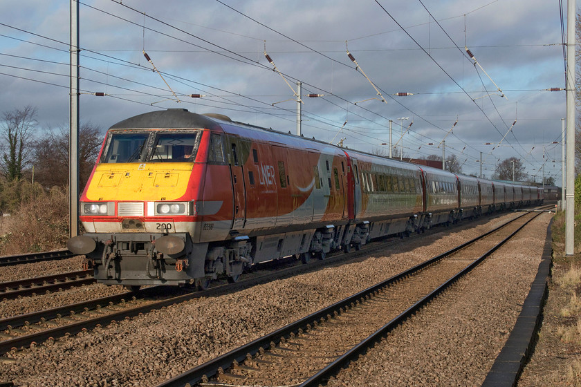 82200 & 91104, GR 09.00 Edinburgh Waverley-London King`s Cross (1E08, 2L), Gill`s Crossing 
 82200 leads the front of the 09.00 Edinburgh to King's Cross with 91104 powering at the rear. The train is passing the village of Offord Cluny in rural Cambridgeshire. Unfortunately, the train is now front-lit as the sun has just gone round too far to illuminate the side but not yet far enough around to light the other side from the western side of the foot crossing; things happen slowly on the day before the winter solstice! 
 Keywords: 82200 91104 09.00 Edinburgh Waverley-London King`s Cross 1E08 Gill`s Crossing LNER