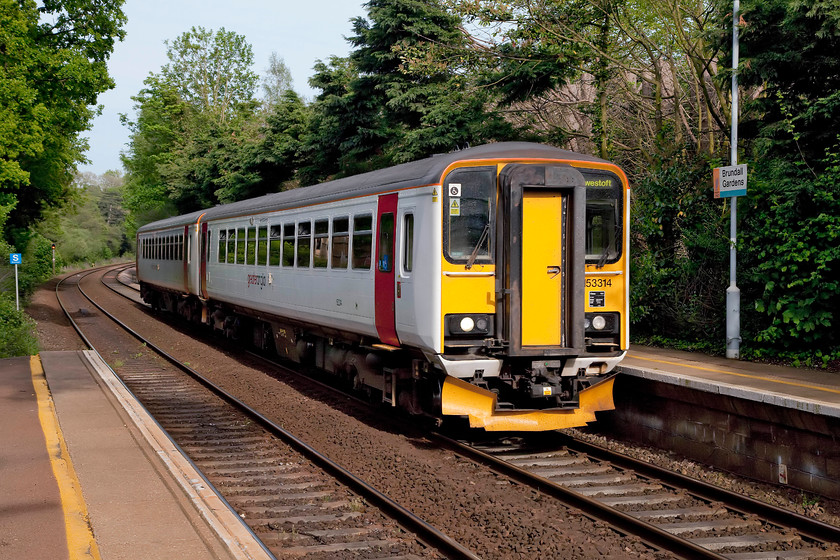 153314 & 153322, LE 16.48 Lowestoft-Norwich (2J85, 1L), Brundall Gardens station 
 Having seen 153314 and 153322 about an hour earlier at Redham swing bridge here they are again with the return 16.48 Lowestoft to Norwich working. They are pictured running non-stop through Brundall Gardens station. This is an interesting little station that is located down some private un-made roads. The car has to be left up on the main road and a short walk taken down to the station. 
 Keywords: 153314 153322 2J85 Brundall Gardens station