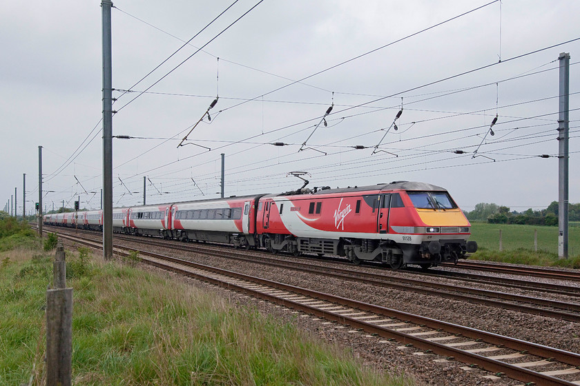 91128, GR 18.03 London Kings Cross-Leeds (1D26, 5L), Langford TL191396 
 91128 'InterCity 50' hauls the evening 18.08 King's Cross to Leeds working past Langford in Bedfordshire. On this section of the ECML the quadruple track is straight making it ideal for fast expresses now an in the past. These class 91s were dubbed the "InterCity 225s" when they were being developed and first introduced. This related to their 140mph design speed. In practice, they have operated at 125mph and given good service over the last thirty years. 
 Keywords: 91128 1D26 Langford TL191396