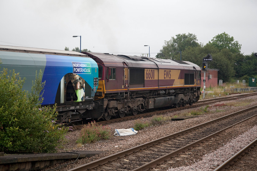 66011, 14.19 Immingham biomass-Drax Power Station (6H75), Hatfield & Stainforth station 
 60011 gets underway from Hatfield and Stainforth station having been held fo a unit to pass. The EWS branded class 66 is leading the 6H75 14.19 Immingham to Drax power station biomass train. This is one of several that run daily to feed the power station's insatiable appetite for its new fuel now that it is longer coal-fired. Notice a previous government's Northern Powerhouse branding on the leading wagon, a policy throwback to the Cameron administration that appears to have been quietly dropped. 
 Keywords: 66011 14.19 Immingham biomass-Drax Power Station 6H75 Hatfield & Stainforth station