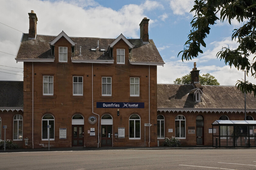 Frontage, Dumfries station 
 The imposing frontage of Dumfries station is seen with my back to the equally impressive Station Hotel. Now, the station is served by a meagre service of assorted units that ply between Glasgow and Carlisle. It once hosted named services such as the Thames-Clyde Express and through sleeper services. Indeed, during my 1984 Scottish Railrover I passed through Dumfries at some frightful hour on the 1S72 Euston to Stranraer sleeper behind 47510 'Fair Rosamund'. Later in the week, I travelled the GSWR Carlisle to Glasgow route again but in daylight. My contemporary notes read, 'Dumfries, a very impressive station, 20201 in the yard'. 
 Keywords: Frontage Dumfries station