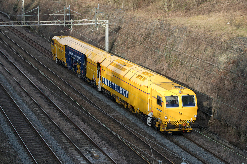 DR75012, 12.20 Nuneaton Civil Engineers-Willesden Railnet Sidings (3L), Hyde Road bridge 
 The third track machine of the day within an hour passes Roade taken from the village's Hyde Road bridge. Swietelsky Babcock Rail's DR75012 heads south as the 12.20 Nuneaton to Willesden bringing a splash of Network Rail yellow to a winter's scene. This Plasser & Theurer Unimat 09-4x4/4S dynamic tamper is almost new being introduced during last summer (2020). 
 Keywords: DR75012 12.20 Nuneaton Civil Engineers-Willesden Railnet Sidings 3L Hyde Road bridge