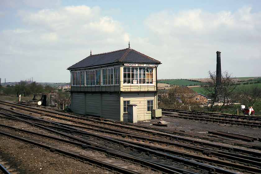 Cudworth South Junction signal box (Mid, date not known) 
 Cudworth South Junction signal box was a short distance north of Station signal box seen in the previous photograph. This is a classic example of a Midland box that is sinking a little in the middle judging by the sagging timbers and roofline. Notice the signalman's Honda 90 moped parked at the top of the cinder path to the box. The mining village of Cudworth is largely hidden behind the box in this image but today it has expanded greatly with virtually all of the farmland behind the chimney now covered with housing estates. The box was closed soon after this date as I have seen a photograph taken in 1984 showing just the base. 
 Keywords: Cudworth South Junction signal box Midland Railway