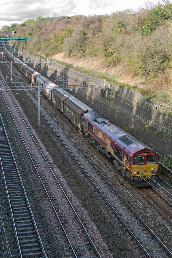 66154, 14.53 DIRFT-Dollands Moor (6O67), Roade cutting 
 Freight three....
As usual, I could hear the 6O67 14.53 Daventry rail freight terminal to Dollands Moor empty water bottle train sometime before it came into view. It is a noisy train due to the empty cargo wagons resonating, indeed living where I do across a field from the WCML I also notice when this train is passing as it sounds so different to everything else. 66154 is leading the train and looks a little tatty still wearing it EWD livery complete with three beasties vinyl on the cab side. 
 Keywords: 66154 14.53 DIRFT-Dollands Moor 6O67 Roade cutting