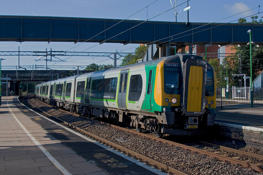 350261, LN 07.56 London Euston-Birmingham New Street (1Y17, RT), Wolverton station 
 350261 arrives at Wolverton station in some welcome sunshine working the 07.56 Euston to Birmingham New Street. The photograph clearly reveals the sharp camber of the track as it passes through the station that applies to both the fast and slow lines. 
 Keywords: 350261 07.56 London Euston-Birmingham New Street 1Y17 Wolverton station London Northwestern Desiro