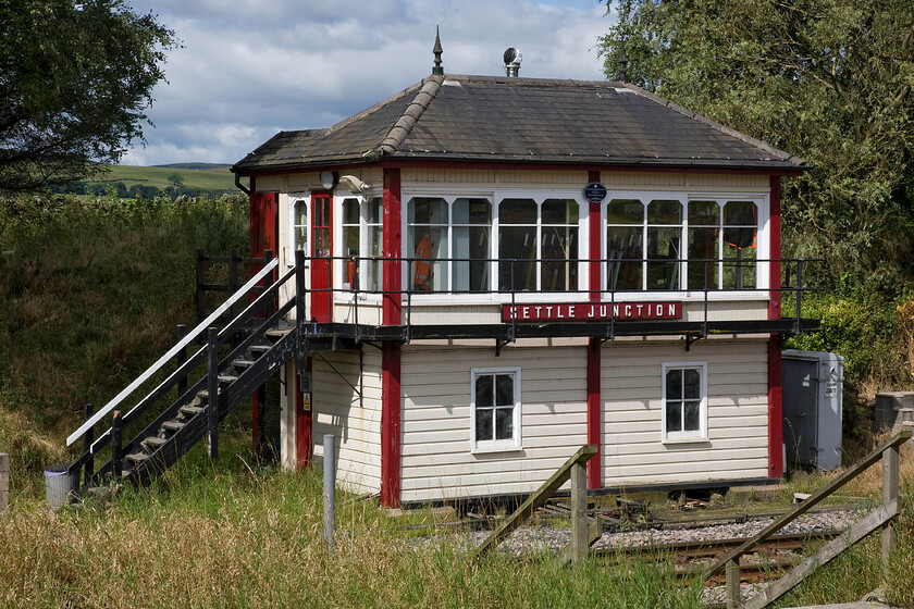 Settle Junction signal box (MR, 1913) 
 Forgive another photograph of Settle Junction but it is such a delightful structure and is extremely well maintained. I stood in a virtually identical spot some thirty-four years earlier (almost to the day!) and took a similar photograph, see...... https://www.ontheupfast.com/p/21936chg/29735524404/settle-junction-signal-box-midland The horrendously busy A65 is directly behind where I am standing meaning that this scene is not a peaceful as it may appear! 
 Keywords: Settle Junction signal box Midland Railway