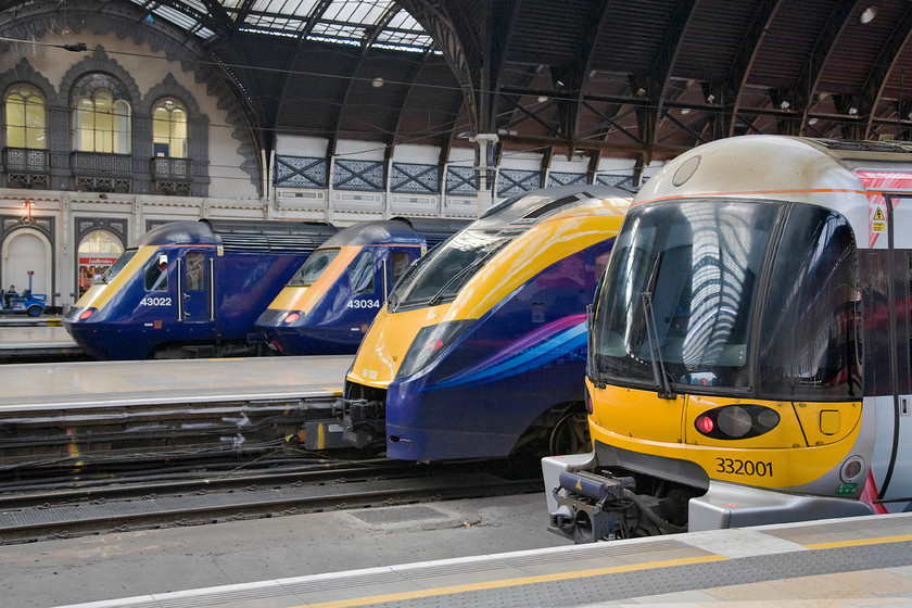 43022, GW 14.15 Paddington-Cardiff (1B42), 43034, GW 14.00 Paddington-BTM (1C17), 180102, GW 14.21 Paddington-Worcester Foregate St (1W21) & 332001, HX 13.55 Paddington-Heathrow (1T61), London Paddington station 
 In a near reverse view of..... https://www.ontheupfast.com/p/21936chg/29941018604/x43094-13-30-london-paddington-bristol a new set of trains occupy the platforms at Paddington. From the furthest to the nearest they are.....

43022, 14.15 Paddington-Cardiff Central, 1B42
43034, 14.00 Paddington-Bristol Temple Meads, 1C17
180102, 14.21 Paddington-Worcester Foregate Street, 1W21
332001, 13.55 Paddington-Heathrow, 1T61

By now all this should have been a thing of the past as the GWML should be nearing completion and nearly operational but the inevitable and costly delays mean that scenes such as this will be about for a year or so yet. 
 Keywords: 43022 14.15 Paddington-Cardiff Central 1B42 43034 14.00 Paddington-Bristol Temple Meads 1C17 180102 14.21 Paddington-Worcester Foregate Street 1W21 332001 13.55 Paddington-Heathrow 1T61 London Paddington station First Great Western HST Adelante Heathrow Express