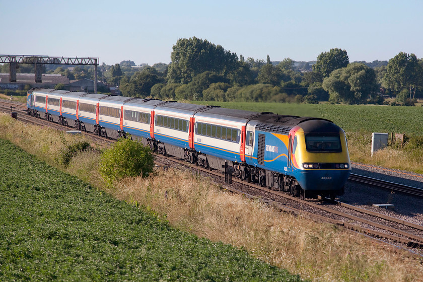 43083 & 43076, EM 17.45 Nottingham-London St. Pancras (1B69, 5E), Harrowden Junction 
 An East Midlands' HST working the 17.45 Nottingham to London St. Pancras passes Harrowden Junction just north of Wellingborough on the Midland Mainline. The HST is led by 43083, which was an Eastern Region power car as part of 254014 whereas 43076, the rear power car, was part of 254011. Close examination of the image sees the driver in a very relaxed poise with both his hands behind his head and his shirt sleeved arms stretched out! 
 Keywords: 43083 43076 1B69 Harrowden Junction