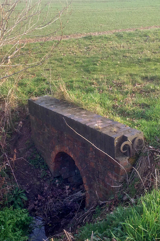 Former SM & J culvert, Roade SP761511 
 This is a culvert that went under an an embankment that carried the SM & J railway across a dip in the fields in the background. This is only a very short distance from my house in Roade. It is from here that I recovered a track chair that I have mounted on a section of sleeper that is now used to hold my driveway gate open. 
 Keywords: SM & J culvert Roade SP761511