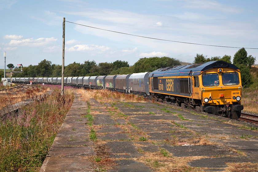 66740, 11.25 Arcow Quarry-Pendleton (6M37), Hellifield station 
 66740 passes through Hellifield leading the 11.25 Arcrow to Pendleton freight. The train has been descending from Arcow through Settle and will continue its journey to Pendleton near Salford via a very roundabout route through Apperley Junction, Wakefield and Rochdale. Notice the overgrown platforms here at Hellifiled station. Trains do not stop at this part of the station and it is only photographers who venture out this far! 
 Keywords: 66740 11.25 Arcow Quarry-Pendleton 6M37 Hellifield station