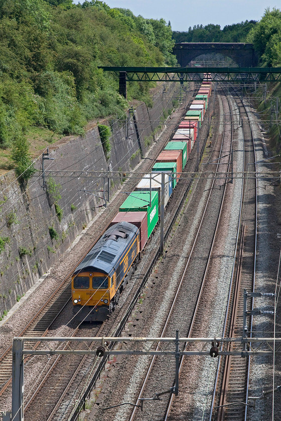 66724, 10.36 Felixstowe North-Hams Hall (4M23, 6E), Roade cutting 
 66724 'Drax Power Station' leads the very heavily laden 4M23 through Roade cutting. Despite using a fairly long lens that compresses things a little, the train still disappears around the corner in the distance and there were still a fair number of wagons out of sight. I have seen and photographed 66724 a number of times but probably the most unusual was passing Salhouse on the Norwich to Sheringham branch, see..... https://www.ontheupfast.com/p/21936chg/23911822404/x66724-13-34-north-walsham-harwich 
 Keywords: 66724 10.36 Felixstowe North-Hams Hall 4M23 Roade cutting Freightliner GBRf GB Railfreight Drax Power Station