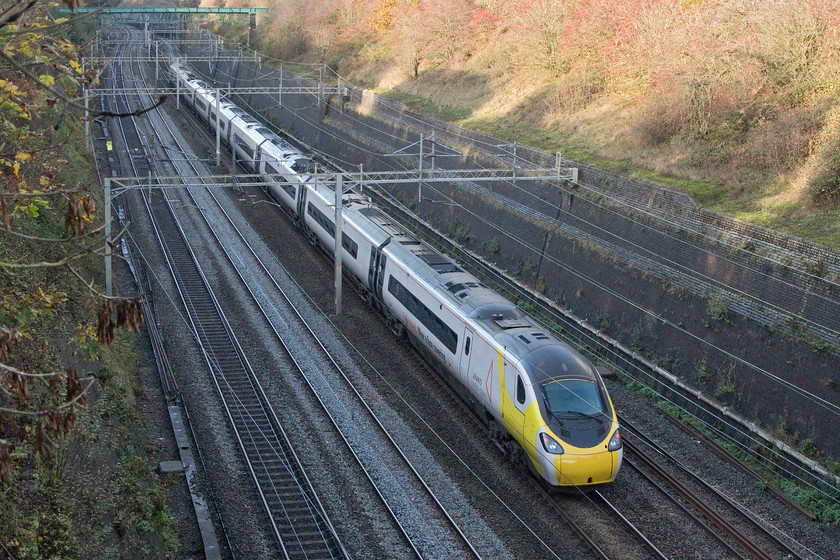 390042, VT 14.07 London Euston-Liverpool Lime Street (1F18, 48L), Roade cutting 
 Wearing its face-covering 390042 passes very slowly through Roade cutting working the 14.07 Euston to Liverpool Avanti West Coast train. This service arrived at its destination nearly fifty minutes late mostly caused by it having to travel on the Northampton loop due to the closure of the Weedon route. It never really recovered any of this lost time but with passenger numbers being so low due to COVID, delay-repay compensation claims would have been lower than normal. 
 Keywords: 390042 14.07 London Euston-Liverpool Lime Street 1F18 Roade cutting Avanti West Coast Pendolino