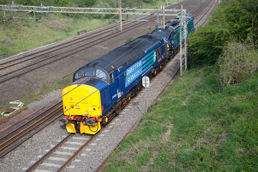 37419 & 68008, 07.18 Crewe Gresty Bridge-Wembley LE move, Victoria bridge 
 A splash of DRS blue rushes through the south Northamptonshire countryside near Roade as 37419 'Carl Haviland 1954-2012' and 68008 'Avenger' make their way as the 07.18 Crewe Gresty Bridge to Wembley light engine move, I never did discover the purpose and the reporting number of this working. 
 Keywords: 37419 68008 07.18 Crewe Gresty Bridge-Wembley LE Victoria bridge