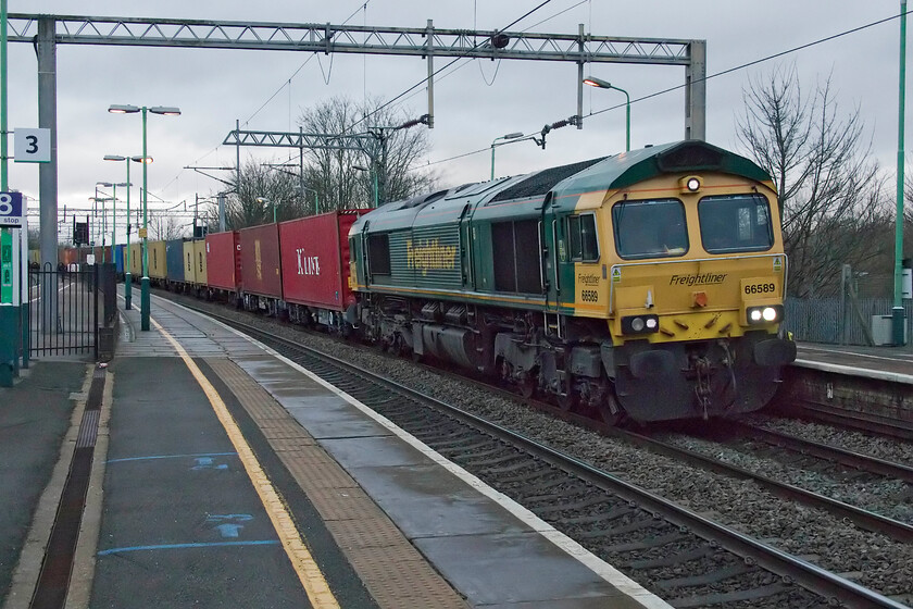 66589, 03.25 Garston-London Gateway (4L52, 3L), Wolverton station 
 In dire lighting that has improved a little from the previous photograph taken some ten minutes earlier, 66589 heads south through Wolverton station leading the 4L32 03.25 Garston to London Gateway Freightliner. With the camera selecting a 10,000 ISO setting the image has needed some Photoshop treatment to get things under a little control. 
 Keywords: 66589 03.25 Garston-London Gateway 4L52 Wolverton station Freightliner