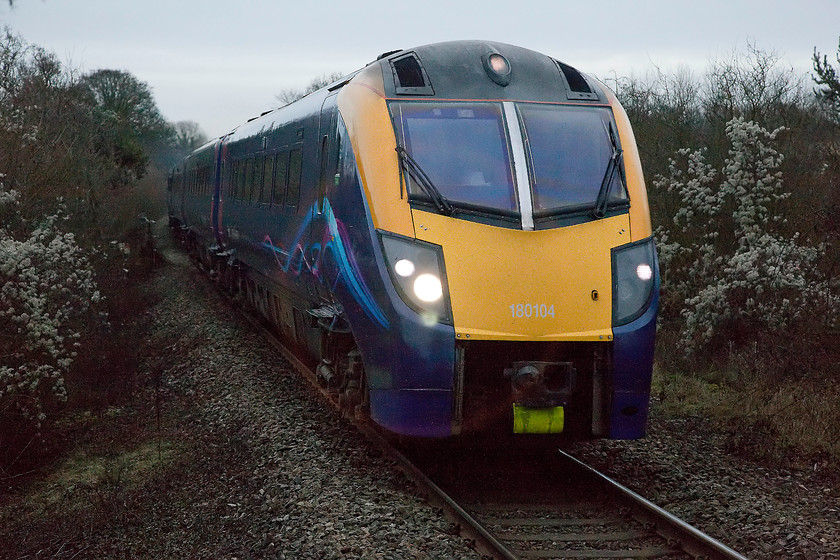 180104, GW 14.21 London Paddington-Worcester Foregate Street (1W29), Combe station 
 This shot demonstrates the capabilities of modern and decent quality digital equipment. It was half light here at Coombe station at 15.35 on a dismal January afternoon and yet the camera has still managed a reasonable shot of a fast moving train at 1/1000th sec. In the days of silver halide film, even Ilford HP5 rated at 400ASA, it would not have managed this task, even if it was 'forced'; and, as for Kodachrome 64, forget it! Great Western 180104 powers the 14.21 London Paddington to Worcester Foregate Street through the diminutive station at Coombe. 
 Keywords: 180104 1W29 Combe station