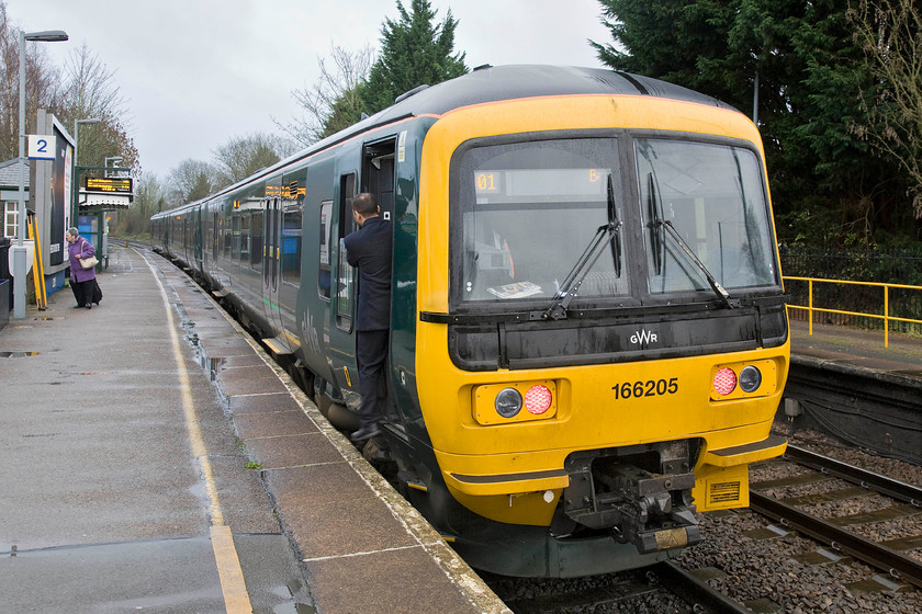 165205, GW 14.08 Reading-Basingstoke (2J39), Bramley station 
 In foul weather at Bramley station 165205 pauses with the 14.08 Reading to Basingstoke shuttle service. I am really not convinced that the new GWR livery applied to their stock is the very best? In poor lighting such as this, it looks somewhat bland but I suppose that it was considered to be 'classy' by those involved in its design! 
 Keywords: 165205 GW 14.08 Reading-Basingstoke 2J39 Bramley station