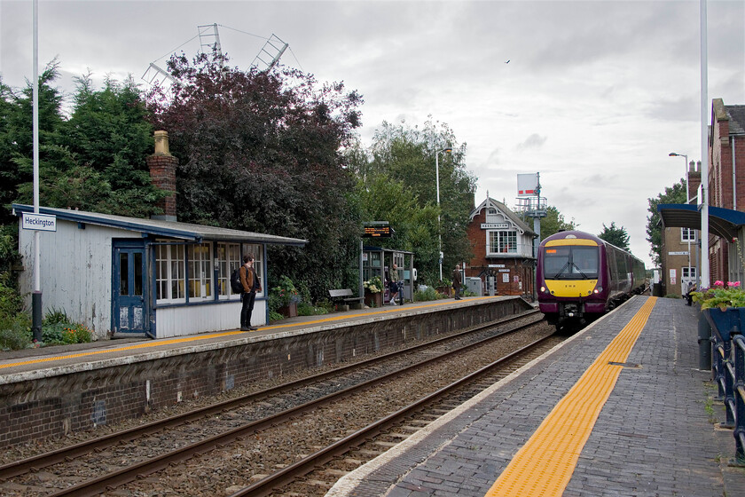 170418, EM 14.46 Nottingham-Skegness (2S21, 12L) Heckington station 
 It's a shame that the trees behind the up platform at Heckington have been permitted to grow so tall as from this angle one used to be permitted not only a fantastically historic railway scene but also the grand windmill, the top three sails of which can just be seen, added extra interest as seen in my 1980 photograph, see....https://www.ontheupfast.com/p/21936chg/29682547404/heckington-signal-box The 14.46 Nottingham to Skegness service arrives at the station worked by 170418. Notice also the superb waiting shelter on the up platform not dissimilar to the North British design seen in the northeast, for example at Acklington, see....https://www.ontheupfast.com/p/21936chg/27318122204/waiting-room-up-platform-acklington 
 Keywords: 170418 14.46 Nottingham-Skegness 2S21 Heckington station E<R East Midlands Railway Turbo