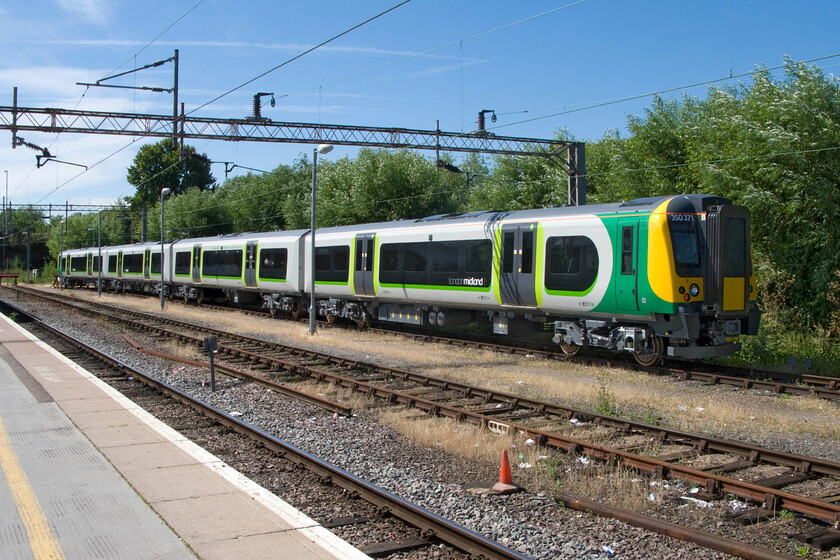 350371 (brand new), stabled, Northampton station Riverside 
 Brand new and wreaking of fresh paint 350371 stands in Northampton's Riverside siding. It has recently been delivered to London Midland and is undergoing mileage accumulation runs prior to it entering service with the TOC. London Midland has ordered ten of these units to supplement their services on their routes and in preparation for the electrification of the Chase Line from Birmingham to Rugeley. Another ten have also been ordered (designated as 350/4 sub-sets) that are heading north to TransPennine Express. 
 Keywords: 350371 stabled Northampton station Riverside London Midland Desiro