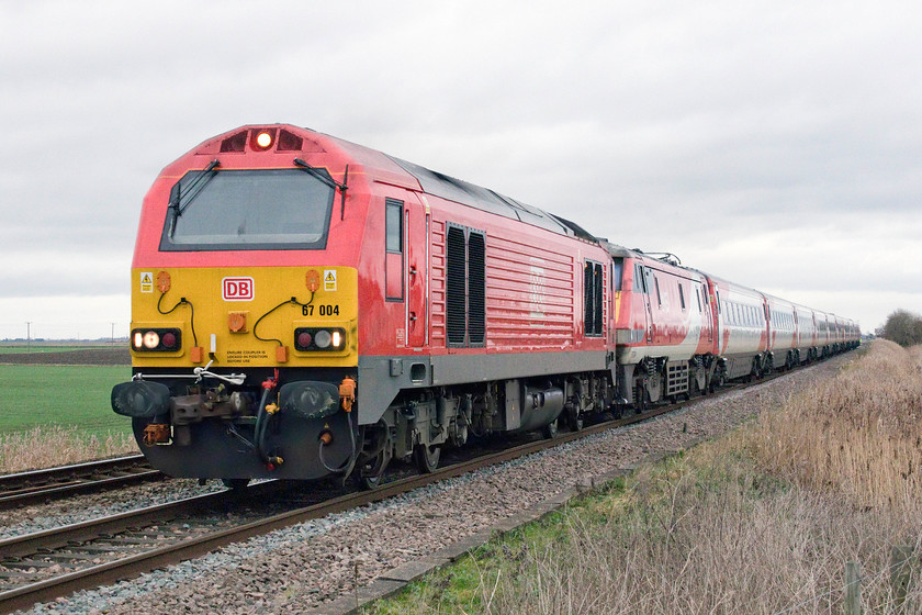 67004 & 91124, GR 09.18 London Kings Cross-Edinburgh (1S13, 20L), Three Horse Shoes no.3 level crossing 
 With the dragging locomotive matching the dragged train, 67004 tows 91124 across the Fens. The 09.18 King's Cross to Edinburgh is seen passing Three Horse Shoes no.3 level crossing between Whittlesea and March. There are three AHB level crossings within three quarters a mile of each other, numbered, unsurprisingly, numbers 1, 2 and 3. 
 Keywords: 67004 91124 09.18 London Kings Cross-Edinburgh 1S13 Three Horse Shoes no.3 level crossing