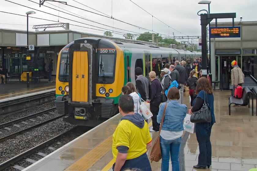 350117, LM 16.34 London Euston-Birmingham New Street, Watford Junction station 
 350117 arrives at a busy Watford Junction station working the 16.34 Euston to Birmingham New Street service. We travelled aboard this train to Milton Keynes where I then took a wet walk to collect the car. Notice the Watford FC fan in the foreground. He will have been making a happy journey home with his team having just got through to the Championship play-off final beating Leicester City in the semis at Vicarage Road. 
 Keywords: 350117 16.34 London Euston-Birmingham New Street Watford Junction station London Midland Desiro