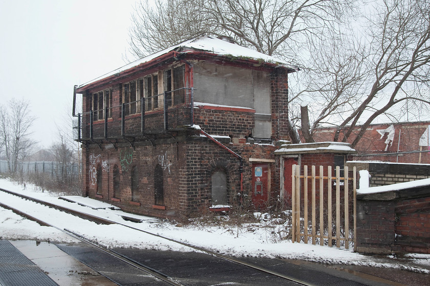 Castleford Gates signal box-closed (NE, 1870) 
 The derelict and sad looking Castleford Gates signal box photographed in the snow. This 1870 North Eastern Railway box was closed in September 1997 and replaced by a Railtrack monstrosity diagonally opposite over the A655 level crossing. One of the reasons for closure was because the McKenzie and Holland frame was completely worn out apart from the fact that all the semaphores were being abolished! I managed a bit of a tight photograph of the box from a passing train when it was still in use back in 1980, see....... https://www.ontheupfast.com/p/21936chg/29385164404/x12-castleford-gates-signal-box-ne 
 Keywords: Castleford Gates signal box NE 1870