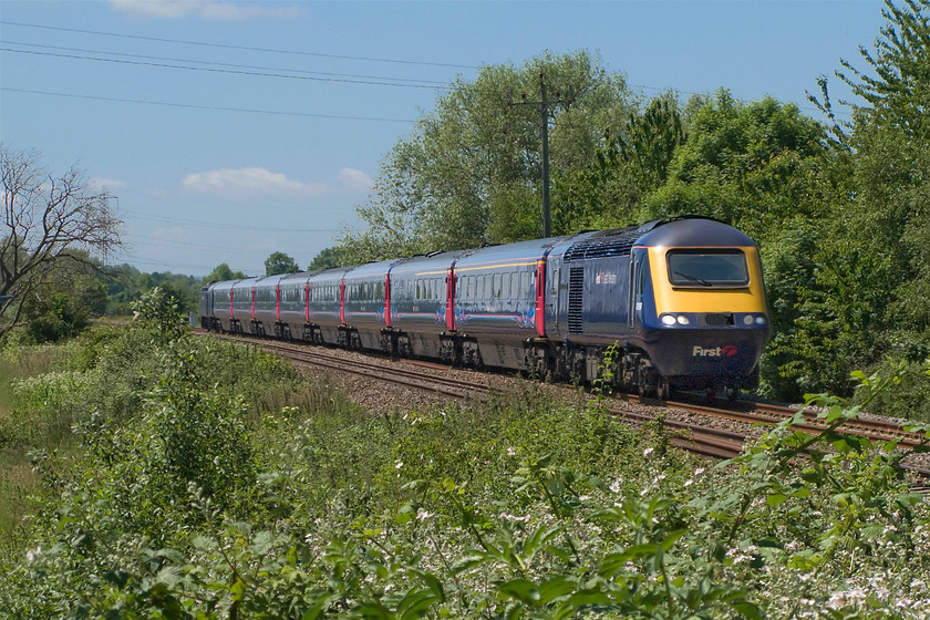 43189, GW 11.30 Paignton-London Paddington (12.17 Exeter St. David`s-London Paddington) (1A82), Victory level crossing, ST182249 
 It may be high summer in the Somerset countryside but all is not well with this First Great Western service. I did not manage to discover the reason but 43189 'Railway Heritage Trust' has started out from Exeter St. David's rather than Paignton where it should have. The 11.30 Paignton to Paddington ran as the 1A82 12.17 from Exeter arriving at Paddington just about on-time. The service is seen descending from Whiteball summit at Victory level crossing deep in the countryside between Taunton and Wellington. 
 Keywords: 43189 11.30 Paignton-London Paddington 12.17 Exeter St. David`s-London Paddington 1A82 Victory level crossing ST182249