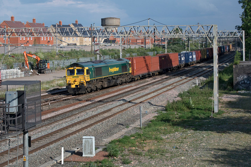 66529, 12.57 London Gateway-Garston (4M57, 13E), site of Roade station 
 Only an hour after the last photograph was taken and conditions have picked up no end! However, that menacing black sky in the background looks rather threatening but adds some drama to an otherwise rather humdrum photograph. 66529 passes Roade leading the 12.57 London Gateway to Garston 4M57 Freightliner. 
 Keywords: 66529 12.57 London Gateway-Garston 4M57 site of Roade station Freightliner