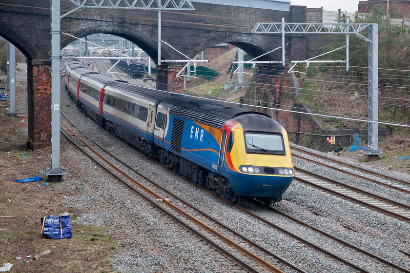 43032, EM 07.45 Nottingham-London St. Pancras (1B18, RT), Wellingborough Driver Way bridge 
 Now some three months into their special dispensation one of East Midlands Railway's HSTs led by 43032 works the 07.45 Nottingham to St. Pancras service on the approach to Wellingborough station passing under Mill Road bridge. The intention was for some of the former LNER HSTs, those compliant with the passengers with restricted mobility legislation, to take over operations on the MML. However, as can be seen here, this has yet to happen. 
 Keywords: 43032 07.45 Nottingham-London St. Pancras 1B18 Driver Way bridge EMR East Midlands Railway HST Wellingborough