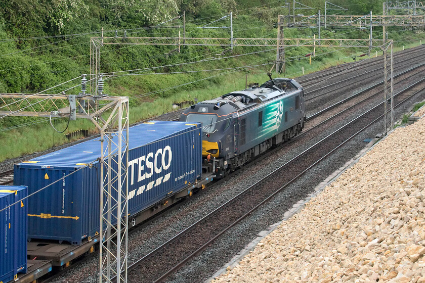 88003, 04.00 Tilbury-DIRFT (4M77, 25E), Ashton Road bridge 
 88003 'Genesis' leads the 4M77 04.00 Tilbury to DIRFT 'Tesco Express' past Ashton Road bridge just south of Roade in Northamptonshire. This service, on arrival at DIRFT, is marshalled and then continues north as the 4S44 to Mossend usually led by the same locomotive, today was no exception with 88003 arriving at its Scottish destination at 19.56. 
 Keywords: 88003 04.00 Tilbury-DIRFT 4M77 Ashton Road bridge Genesis