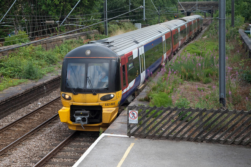 333003, NT 15.33 Leeds-Ilkley (2V42, 4L), Guiseley station 
 333003 drifts into Guisley station forming the 15.33 Leeds to Ilkley. I am not sure if I like the look of these class 333 units, I suspect that when they were introduced in 2000 they were the ultimate in modern design and cut quite a look. They were extended in 2007 from being three-car to four-car units. 
 Keywords: 333003 2V42 Guiseley station