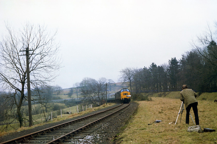 37233 & 37269, outward leg of The Gwent Valley Invader, Crewe-Blaenavon (1Z46), Blaenavon SO254080 
 After a frantic chase with five of us in a Mini, we managed to catch the railtour up as it approached Blaenavon. In this image, Graham is seen capturing the spectacle on his 8mm cin camera whilst recording the sound on his substantial TC-153SD Sony cassette recorder laying in the grass. He would also have managed to take a slide on his still camera. 37233 and 37269 approach Blaenavon at OS map reference SO254080 near to the terminus of this leg of the trip. This point is approximately the spot where the Pontypool and Blaenavon Railway's extension terminates today. 
 Keywords: 37233 37269 The Gwent Valley Invader Crewe-Blaenavon 1Z46 Blaenavon SO254080