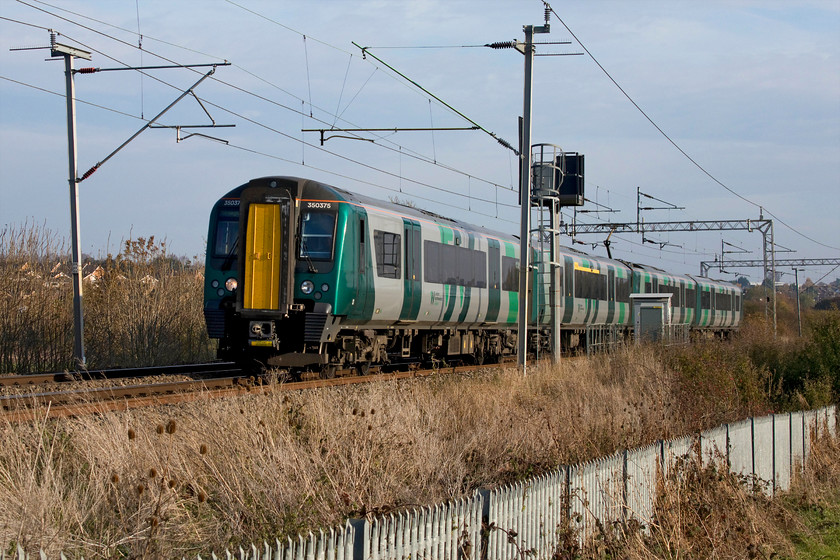 350375, LN 12.49 London Euston-Birmingham New Street (1W13, 4L), Wilsons Crossing 
 Looking different in its new London NorthWestern livery, 350375 passes Wilson's Crossing north of Northampton with the 12.49 Euston to Birmingham New Street service. The future of this flat foot crossing is under constant review. With the announcement of a huge housing development that will cover the fields in this area, I suspect that a footbridge or tunnel will be provided at this spot. 
 Keywords: 350375 12.49 London Euston-Birmingham New Street 1W13 Wilson's Crossing