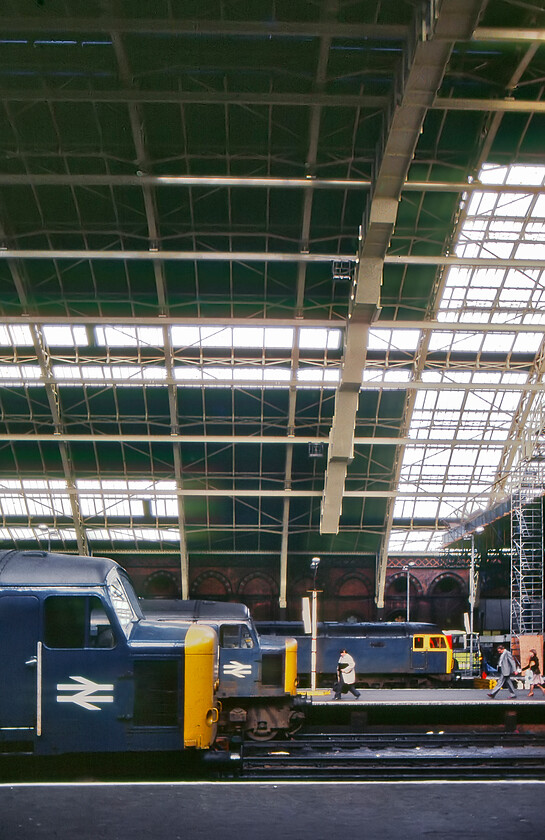 Class 45s & 47, unidentified workings, London St. Pancras station 
 Unfortunately, my contemporary notes do not record the locomotive numbers and their respective workings in this view at St. Pancras. The only one that I can confirm is that the first Peak is 45123 'The Lancashire Fusilier' that had recently arrived with the 14.07 from Derby. This view also reveals the restoration of the Barlow trainshed that is being undertaken with the wrought iron frame having received a fresh coat of paint. Much of the glazing remains covered up leading to a dark interior at platform level. 
 Keywords: Class 45s 47 London St. Pancras station Peak The Lancashire Fusilier