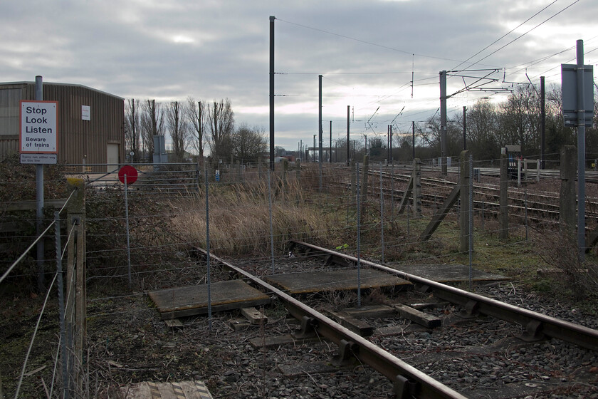 Former rail access, Dowmac, Tallington 
 A second view of the disused rail link into the Dowmac concrete plant adjacent to the ECML at Tallington. With the mainline in the background the Tallington footbridge, located next to the village's level crossing, can also be seen. Preformed concrete items are still taken away from the plant on a regular basis by rail but trains now access via the second track from the left with the ground frame that controls entry and exit to the far right. 
 Keywords: Former rail access Dowmac Tallington