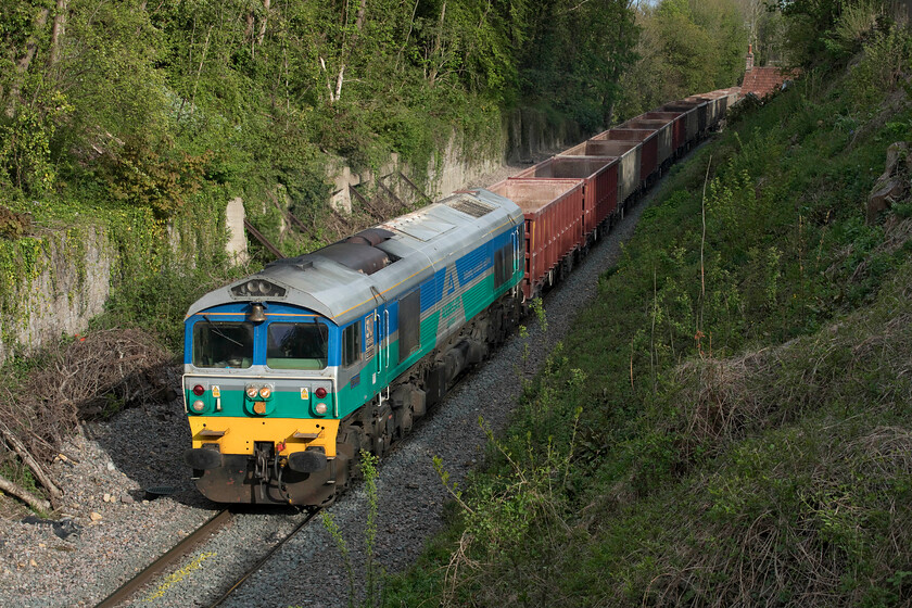 59001, 14.39 Acton-Whatley (6C76, 18E), Frome North Parade bridge 
 Pioneer 59001 'Yeoman Endeavour ' passes through Frome with the 14.39 Acton to Whatley 6C76 stone empties. Notice that this Class 59 carries a bell that was fitted when the locomotive was named in a ceremony at Merehead quarry on 28.06.86 to celebrate the entry to service as one of the initial batch of three locomotives following exhaustive testing and driver training. Back then, little did we know what a profound impact these North American built locomotives would have on our railways. Whilst this looks to be a quiet and rural spot the photograph is taken from the very busy North Parade road bridge close to Frome's town centre. 
 Keywords: 59001 14.39 Acton-Whatley 6C76 Frome North Parade bridge Yeoman Endeavour