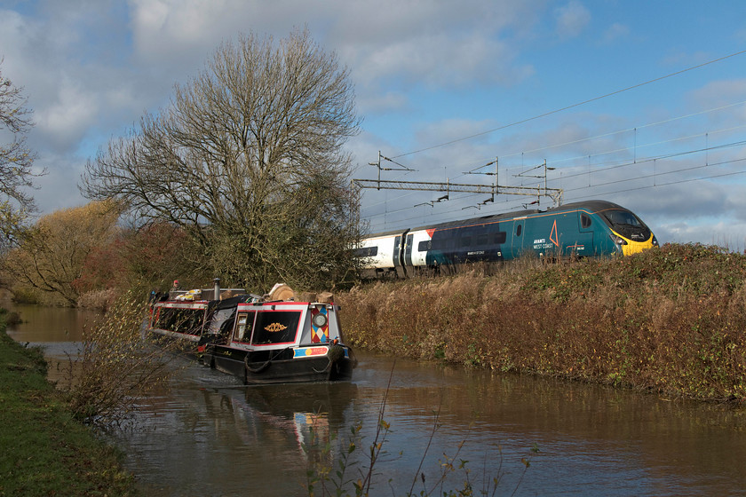 390047, VT 11.02 Preston-London Euston ECS (5T91, 16L), Stretton Wharf SP432810 
 390047 runs along the side of the Oxford Canal near Stretton Wharf passing a far more sedate form of transport from another era. The Pendolino is forming the 11.02 Preston to Euston 5T91 empty stock working whilst 'Alice Too' takes its owners on a pleasure trip. This classic location in northern Warwickshire is somewhat compromised now by growth on the embankment but it is a lovely spot to wait for and watch trains pass! 
 Keywords: 390047 11.02 Preston-London Euston ECS 5T91 Stretton Wharf SP432810