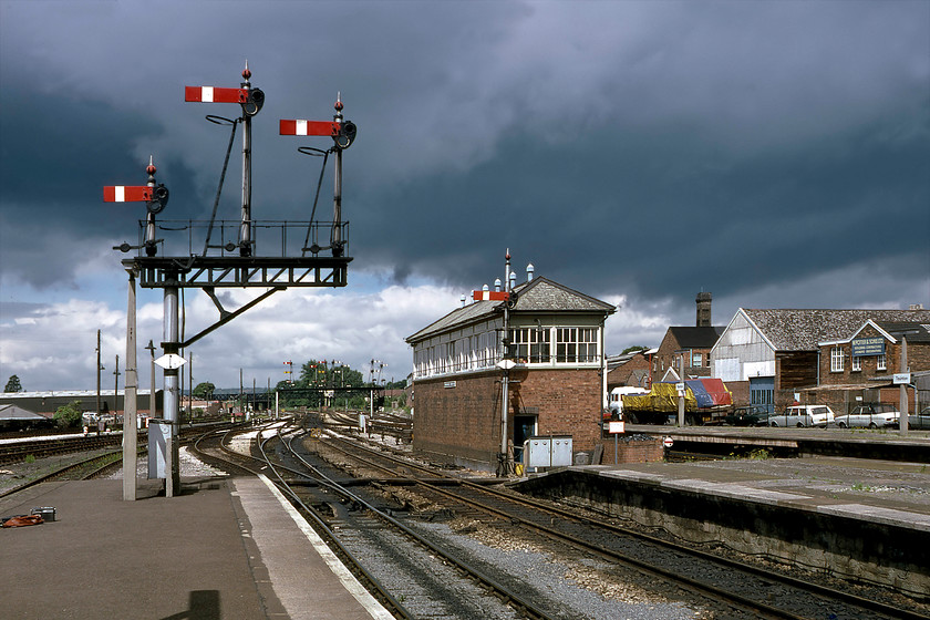 Taunton West signal box (GW, 1931) & signalling 
 Under a dramatic sky is the veritable feast that is the signalling to the west of Taunton station! On the platform end is the three doll bracket carrying the down home arms at different heights indicating their relative importance. Beyond the box, in the distance, is the amazing gantry housing the inner homes and down starters. The track layout and signalling dates from the early 1930s when the GWR was making strenuous efforts to improve timings for their fast express trains to the West of England raising line speeds through bottleneck stations such as Taunton. The box and semaphores stayed in use for another six years from when this photograph was taken being unceremoniously wiped away in May 1986. Notice my Ferguson 3286 radio cassette recorder on the platform to the extreme left. As it transpired, this was to be its last trip out as it was about to be replaced by a new Sony TC525 cassette recorder that I had been frantically saving for over a number of months. 
 Keywords: Taunton West signal box signalling