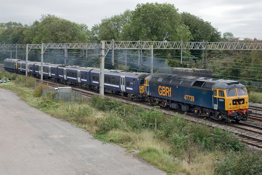 47739, 360103 & 47727, 11.52 Ilford EMUD-Northampton EMD (5Q60, 3E), site of Roade station 
 Groundhog day at the site of Roade station! Last Sunday, see.... https://www.ontheupfast.com/p/21936chg/29562233604/x47739-360113-47727-11-52-ilford I photographed the same train being handled by the same locomotives at the same location but, as the weather was considerably better, from the other side of the line! The only difference was the Class 360 unit being dragged by 47739 and 47727 'Edinburgh Castle/Caisteal Dhun Eideann'. Whilst last week it was 360113 this week it is 360103 being taken to the Siemens depot at Kingsheath for modifications. 
 Keywords: 47739 360103 47727, 11.52 Ilford EMUD-Northampton EMD 5Q60 site of Roade station GBRf Edinburgh Castle/Caisteal Dhun Eideann